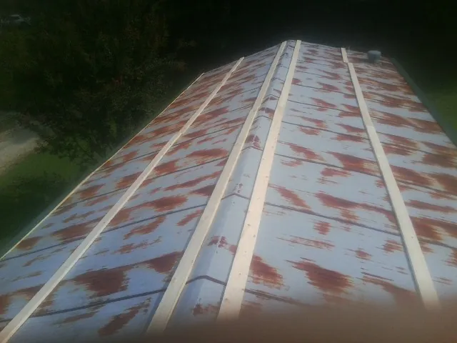 Rusted metal roof panels with new wood purlins before replacement — Storm Damage Roof Repair in Walnut Grove by Roofing Brothers