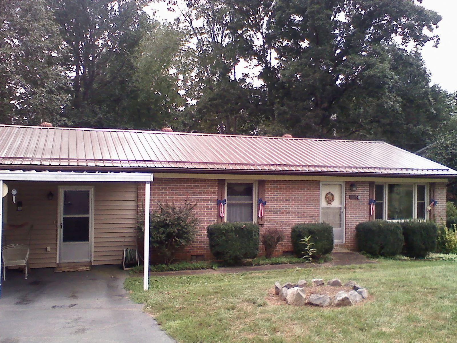 Bronze metal roof and carport on a brick ranch home — Roof Repair work by our crew in Walnut Grove